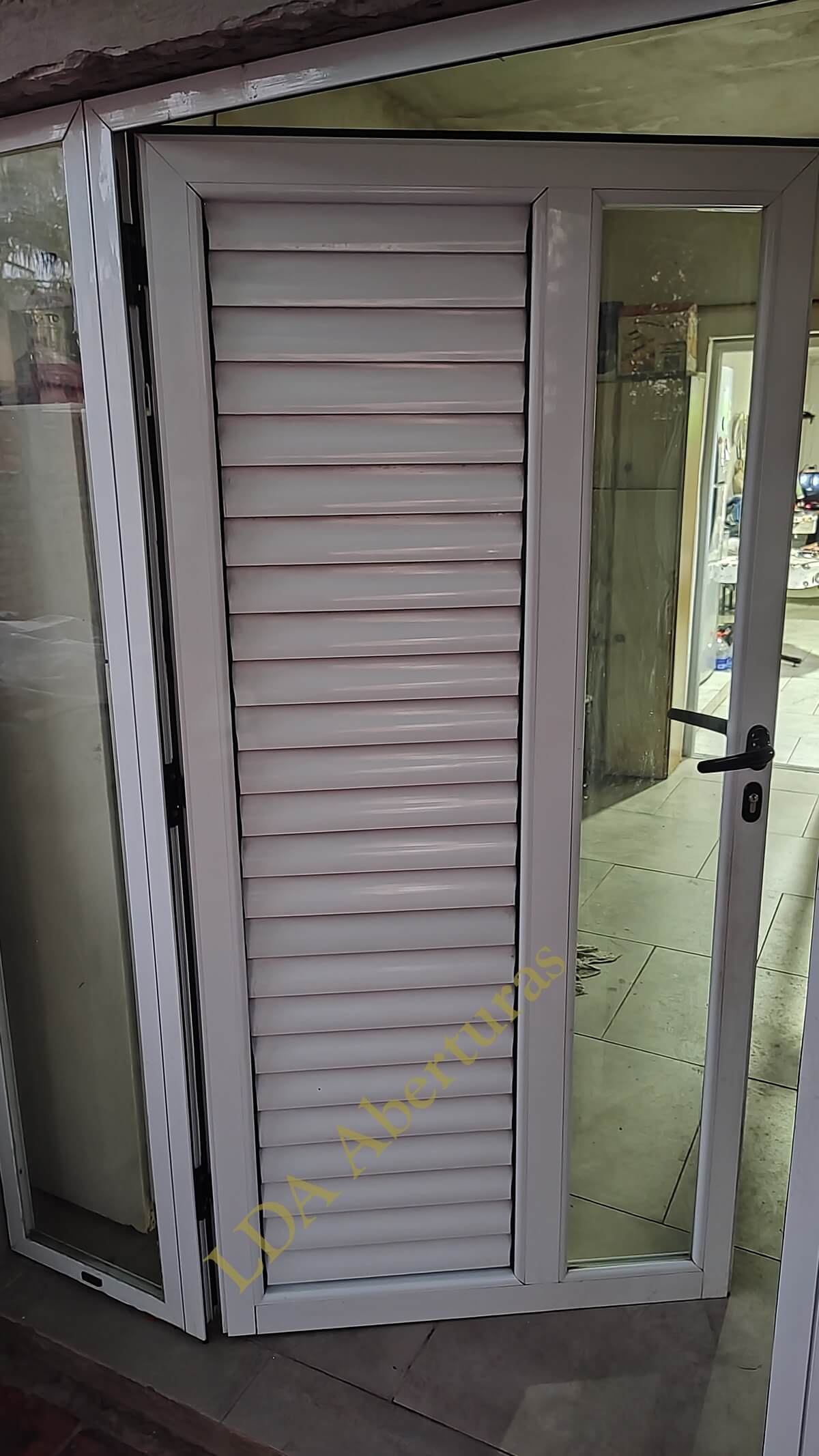 Puerta de aluminio con persiana plegable